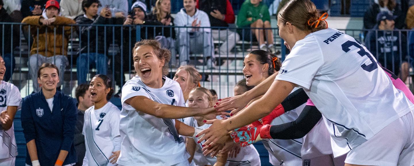 A Penn State scorer sprints into a wall of outstretched hands from the bench
